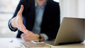 Businessman extending his hand for a handshake, symbolizing How to Negotiate Better Staffing Rates.