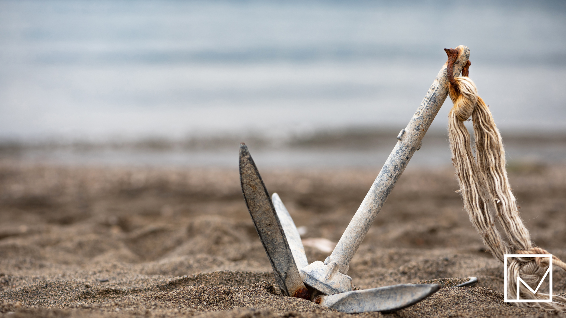 Boat anchor resting on a sandy beach, symbolizing the sales strategy of price anchoring.