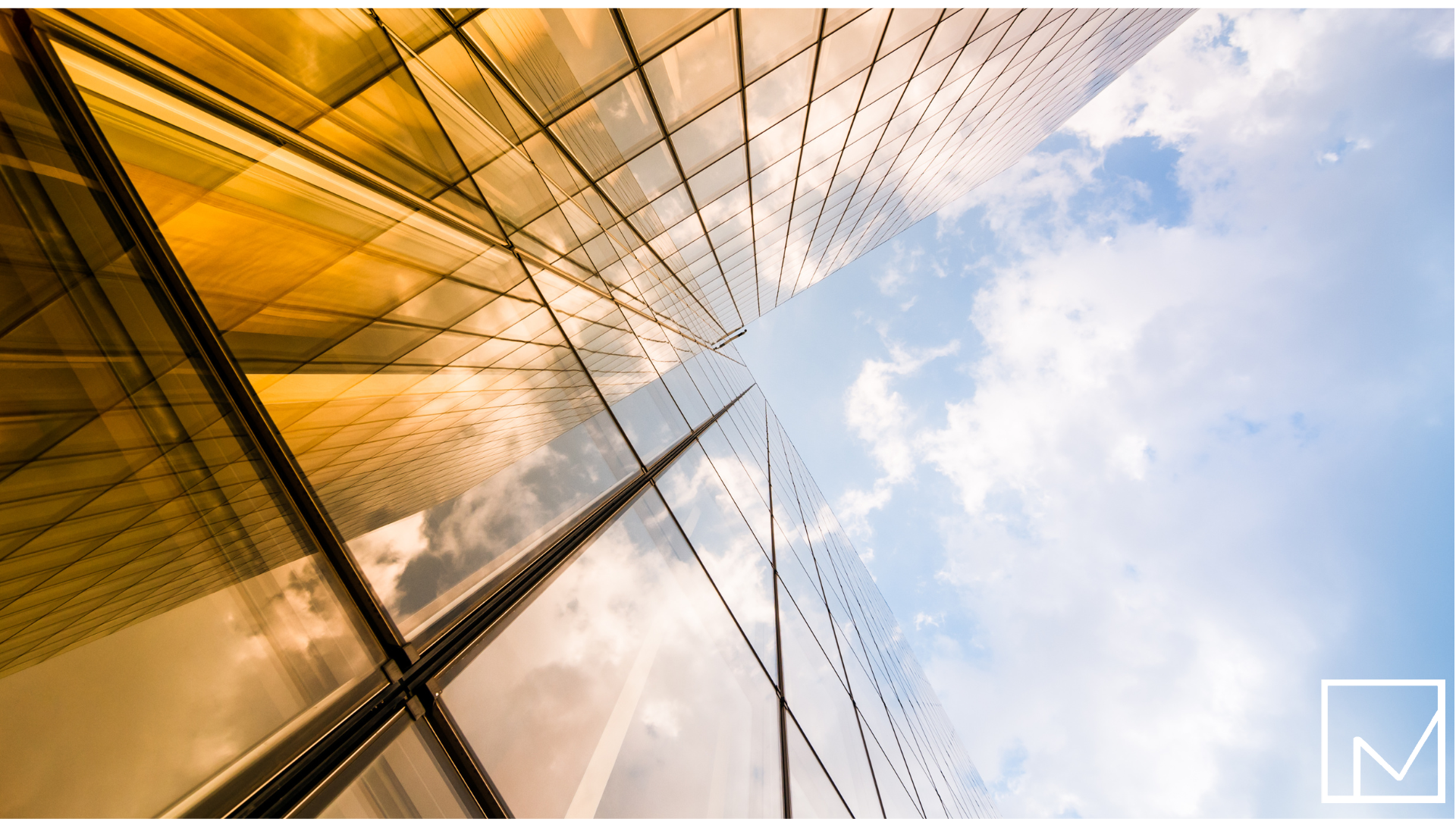 Upward view of a skyscraper against a blue sky, symbolizing business growth and opportunity ahead.