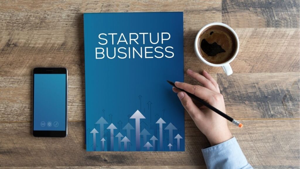 Startup business plan on desk with coffee and phone, representing launching and growing a staffing agency.