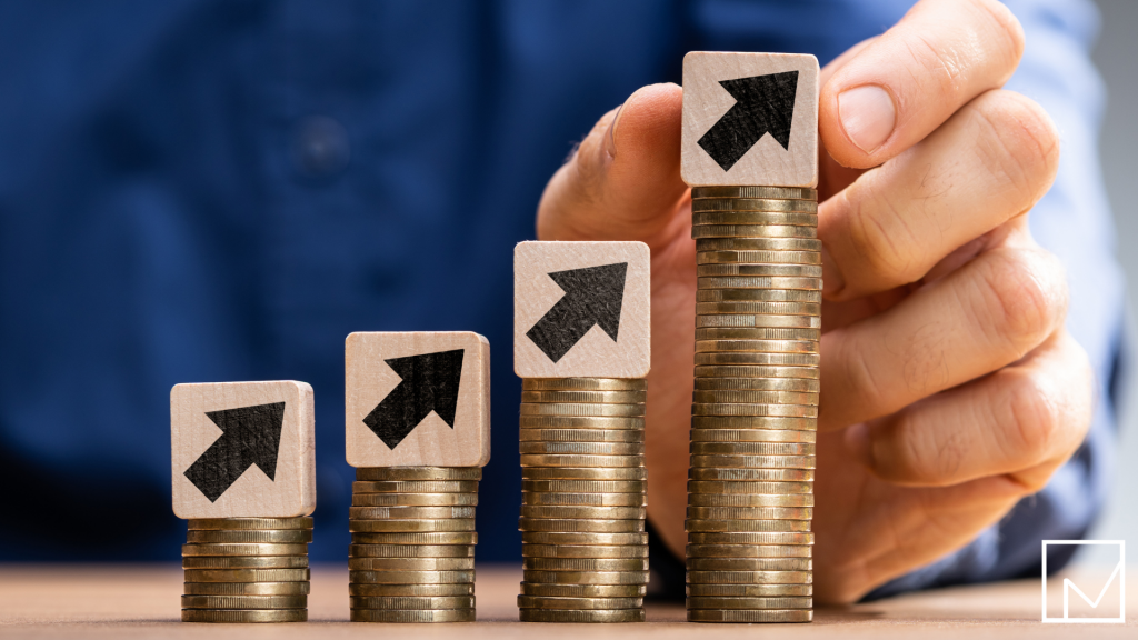 Man placing blocks upward on top of growing stacks of coins, symbolizing how contract staffing increases the value of a company.
