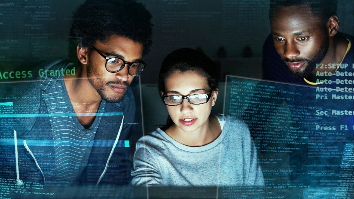 IT professionals analyzing code on screens, representing technology-driven staffing growth and how payroll funding supports scaling in today’s competitive tech market.