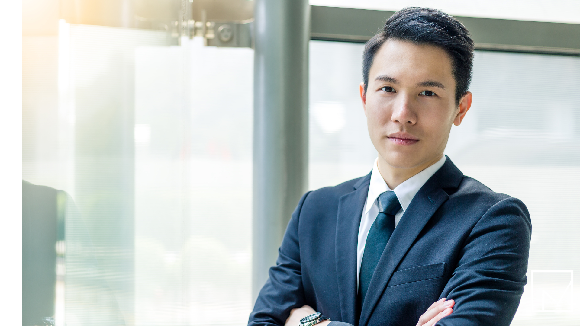 Confident businessman in a suit with arms crossed, representing a successful salesperson turned entrepreneur.