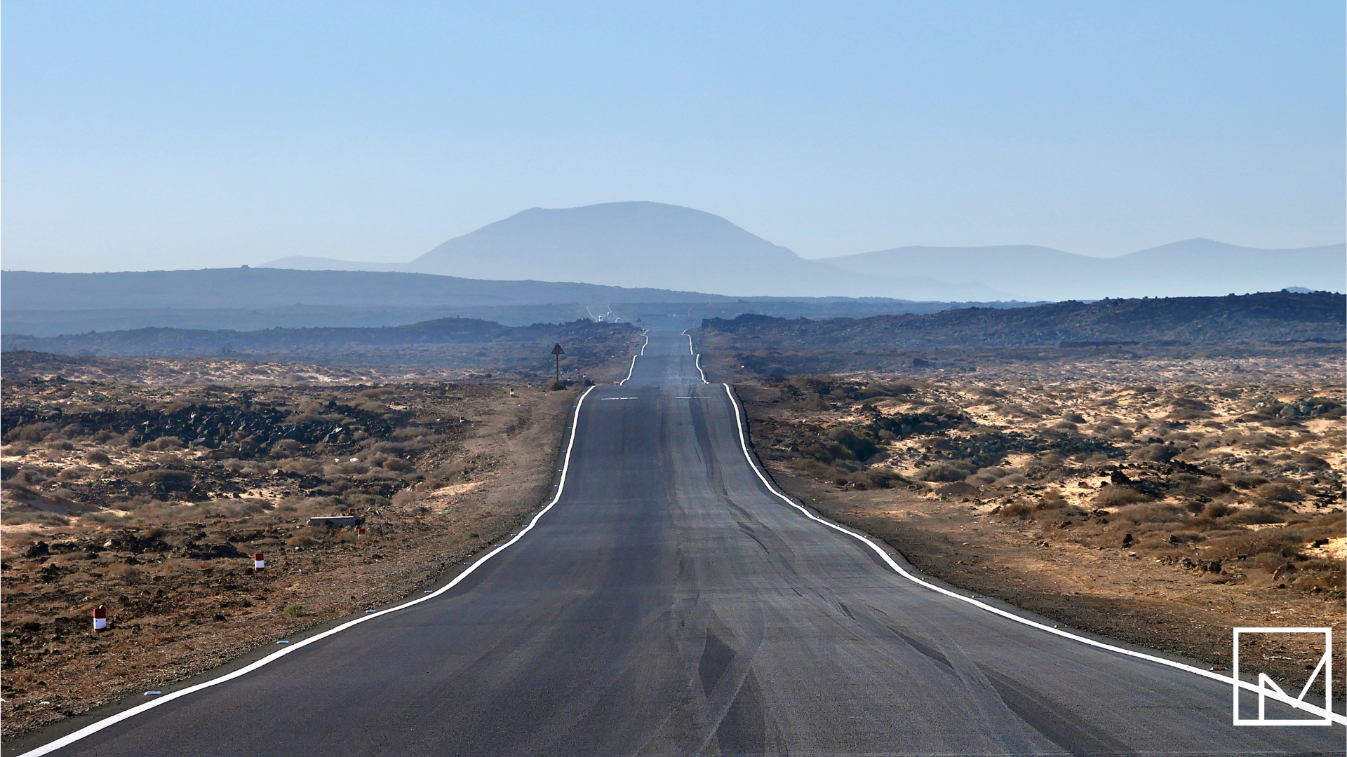 A long, empty road stretching through a desert landscape, symbolizing the 50-mile distance that unlocks tax-free per diem benefits for traveling contractors.