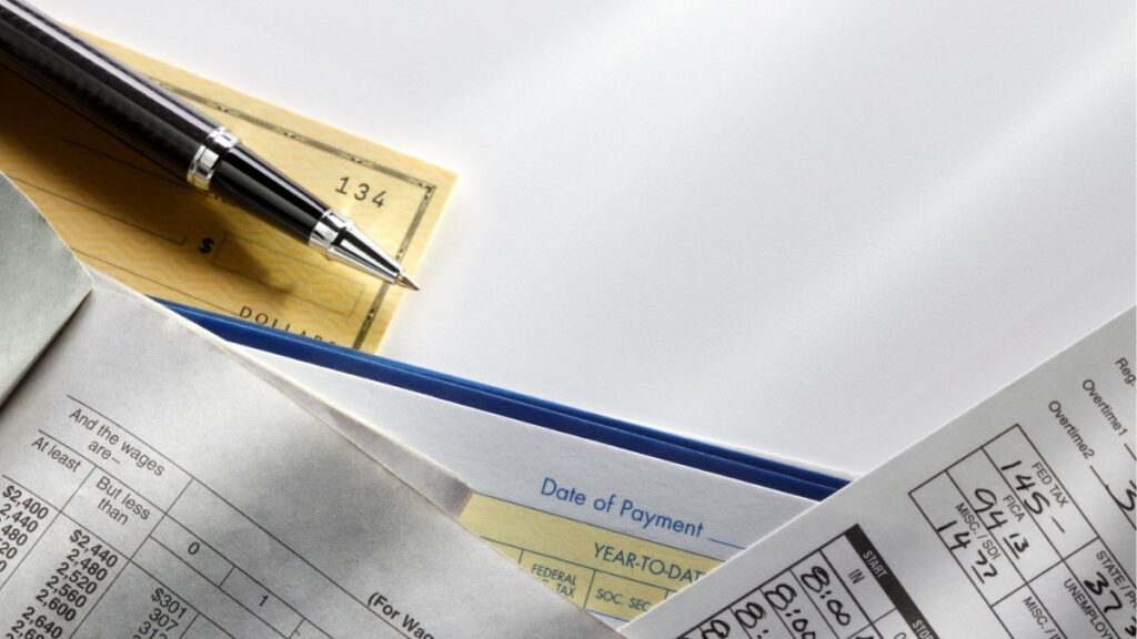 Payroll checks, tax documents, and payment records representing payrolling for staffing firms.