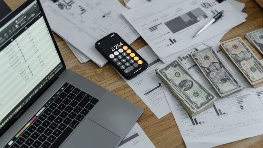 Financial reports, cash, and calculator representing growth and success in a staffing business.