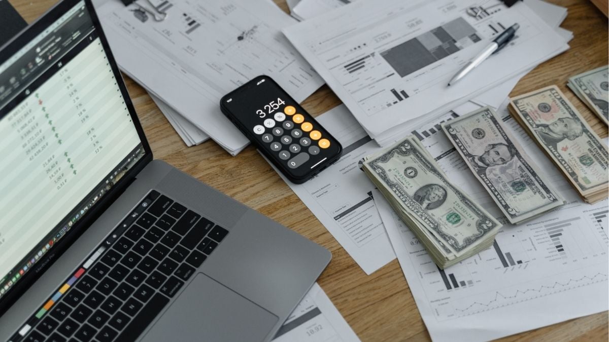 Financial reports, cash, and calculator representing growth and success in a staffing business.