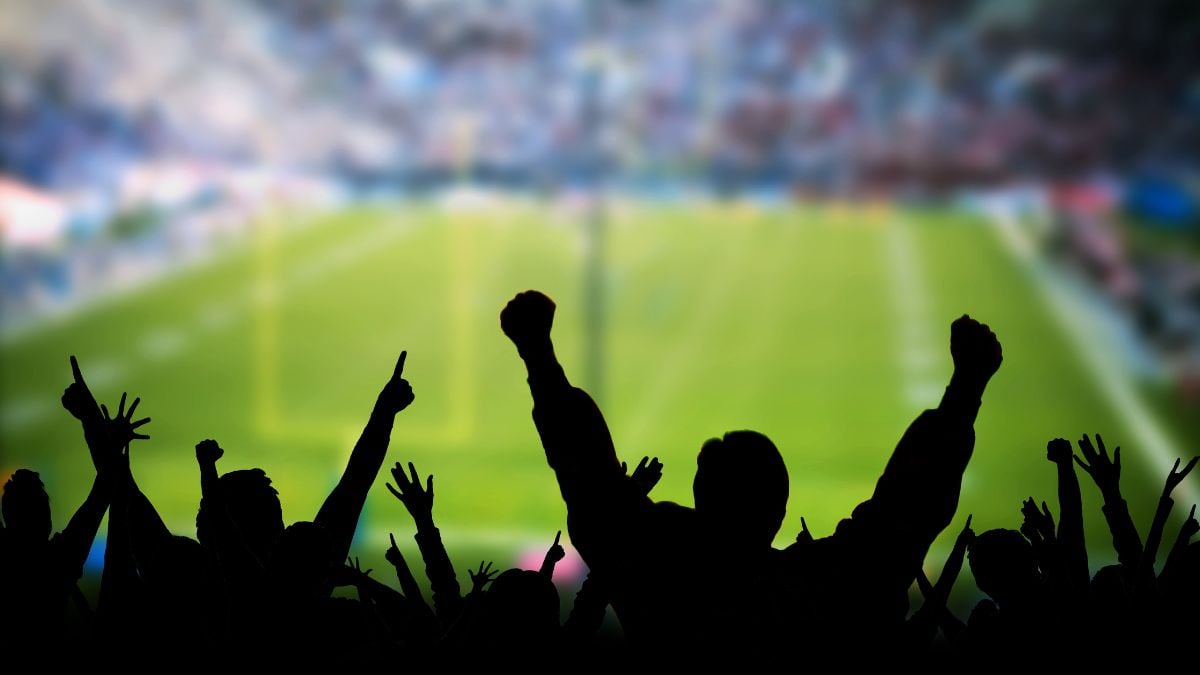 Excited crowd cheering at event representing strong customer loyalty and raving fans.
