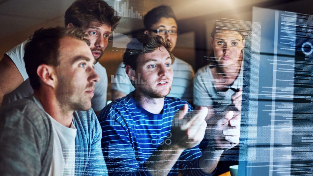 Team of IT consultants analyzing data and code on a screen, representing technology staffing and project-based IT work.