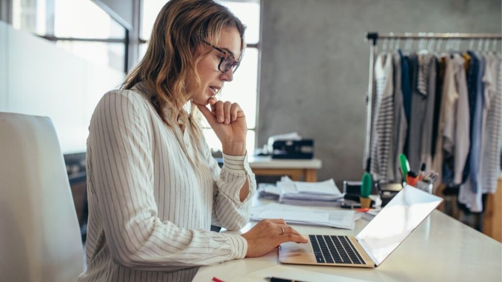Professional reviewing updates on a laptop representing Madison Resources news, industry insights, and company announcements in staffing and payroll funding.