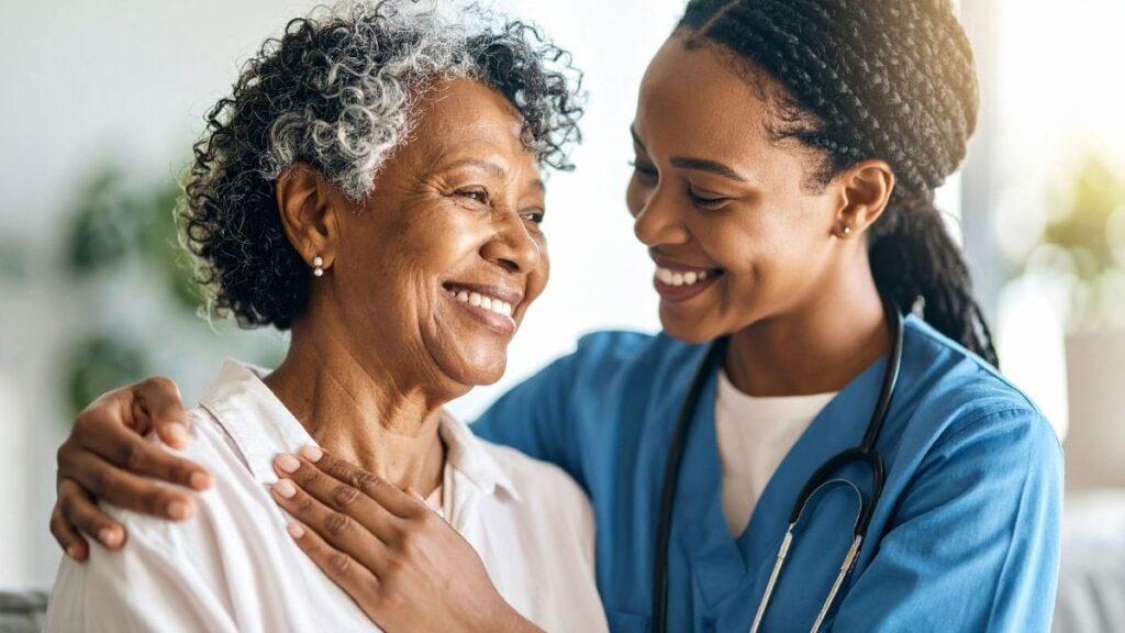Travel nurse providing compassionate care to an elderly patient, representing healthcare staffing and payroll funding support for travel nurse agencies.
