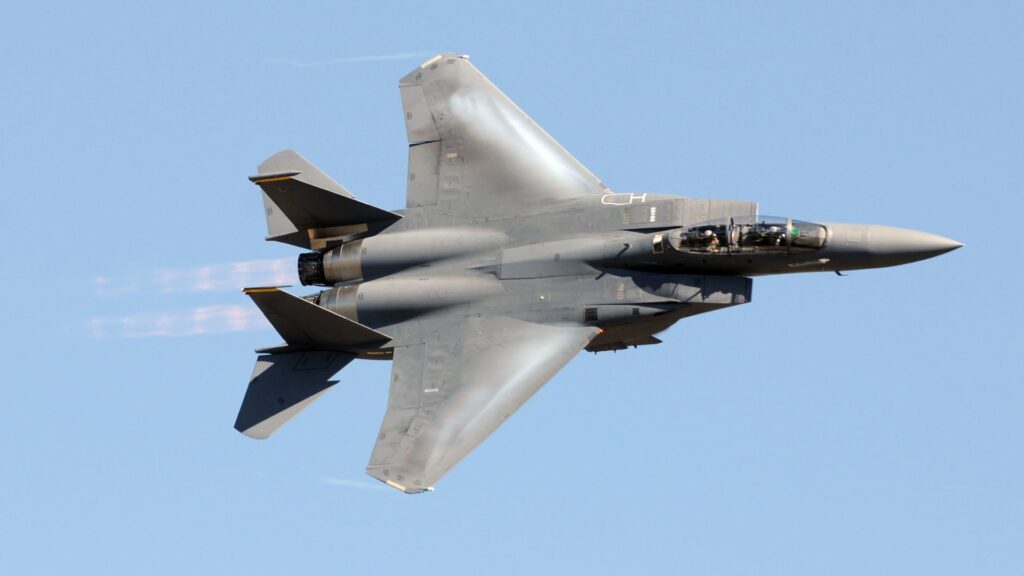 Military aircraft in flight representing defense and government contract staffing supported by reliable payroll funding.