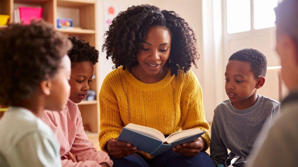 Teacher reading with students in a classroom, representing consistent staffing and support enabled by strong cash flow in education staffing.