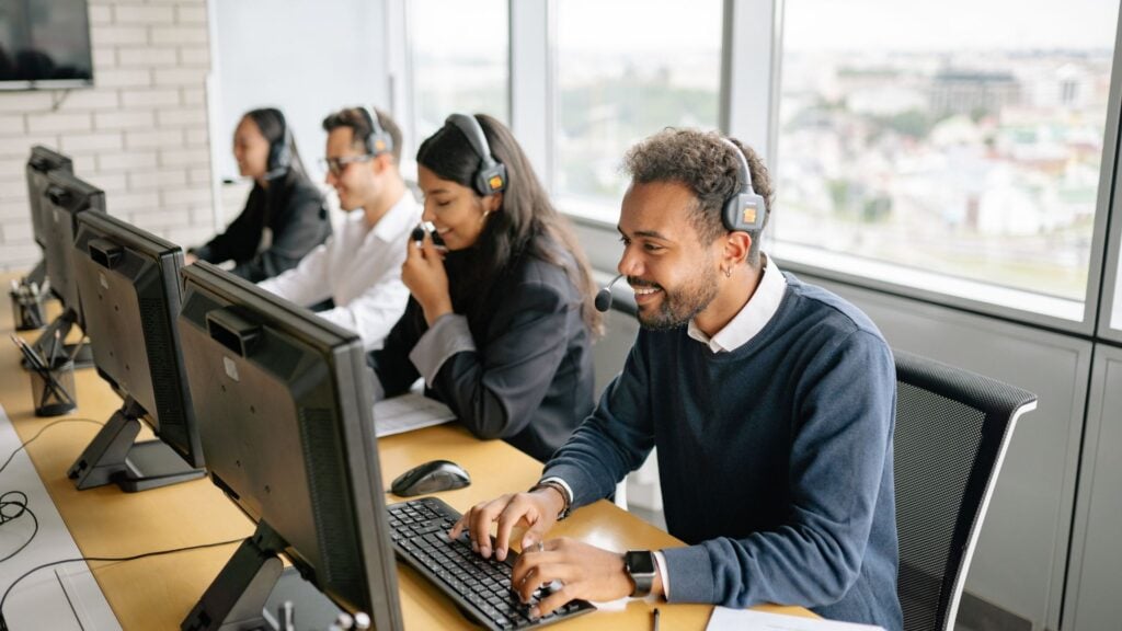 Call center and customer service team working at computers, representing office and clerical staffing placements.