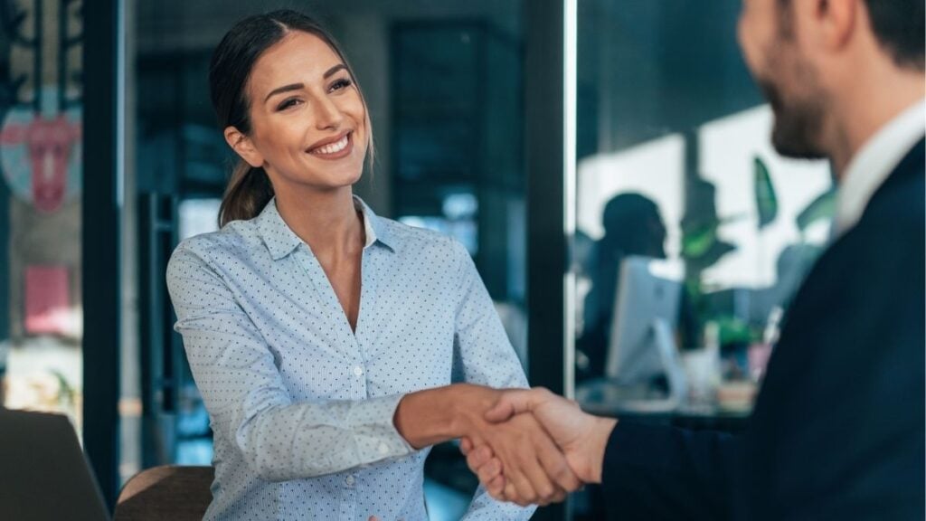 Business professionals shaking hands, representing back office services and operational support for staffing firms.