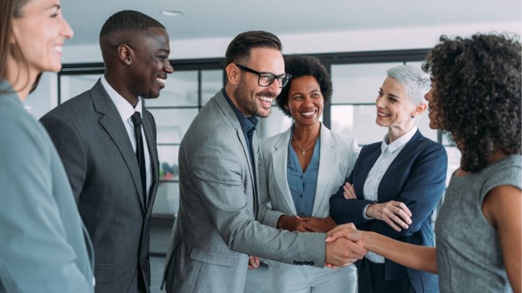 Business professionals shaking hands, representing full-service payroll funding and back office partnership for staffing firm growth.