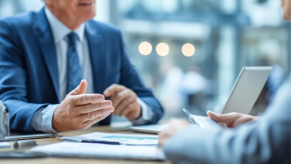 Business professionals discussing financial documents, representing funding-only payroll solutions for staffing firms and improved cash flow.