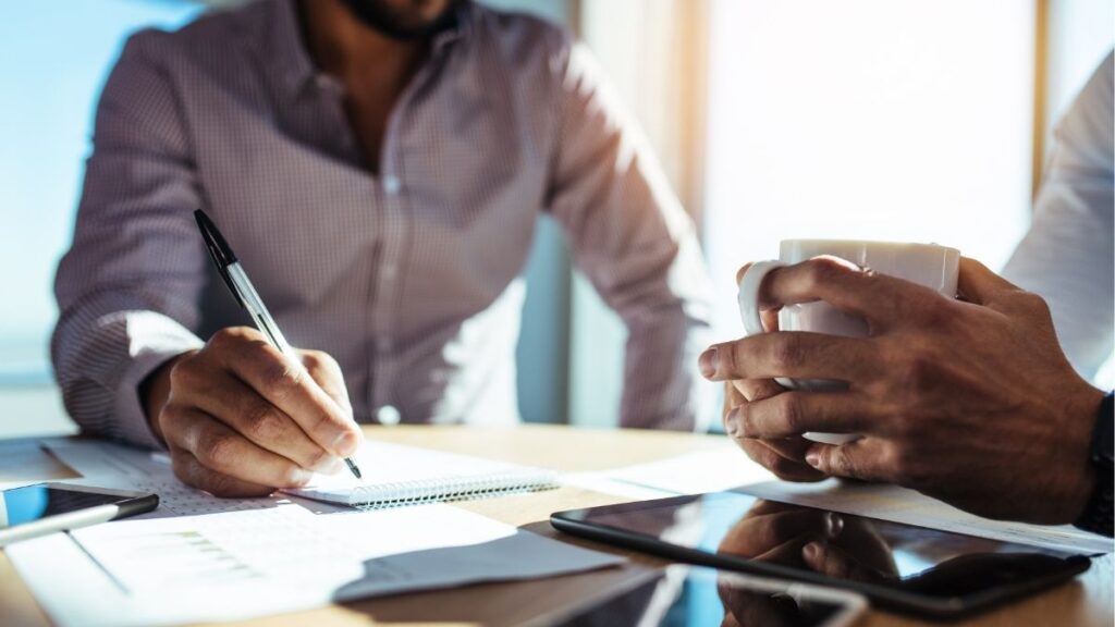 Business professionals reviewing payroll and tax documents, representing staffing payroll tax services, reporting, and compliance management.