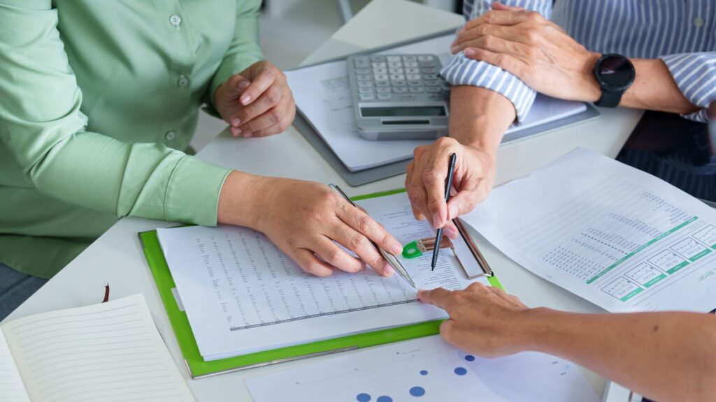 Business professionals reviewing financial reports and payroll data, representing payroll funding and back office support for staffing firms.