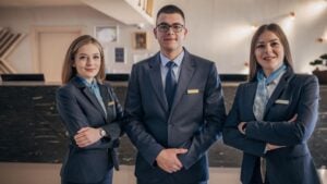 Hospitality Staffing Growth Preparing for Seasonal Demand - Madison Resources Hospitality staffing professionals standing at a hotel reception desk, representing hospitality staffing growth during seasonal demand and peak travel periods.