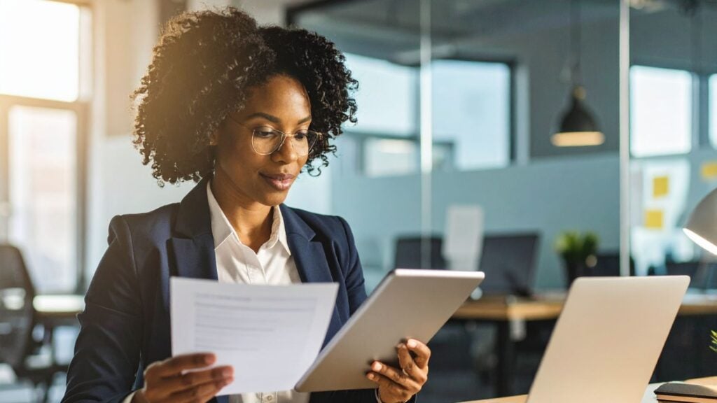 recruiter reviewing employment contract for staffing firm non-compete agreement - Madison Resources - Madison Resources Staffing recruiter reviewing an employment contract and digital documents while evaluating a non-compete agreement in a modern office.