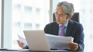 Man at desk reviewing charts showing money only funding for his staffing firm.