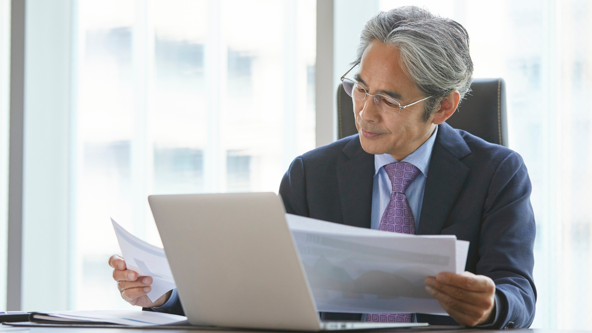 Man at desk reviewing charts showing money only funding for his staffing firm.