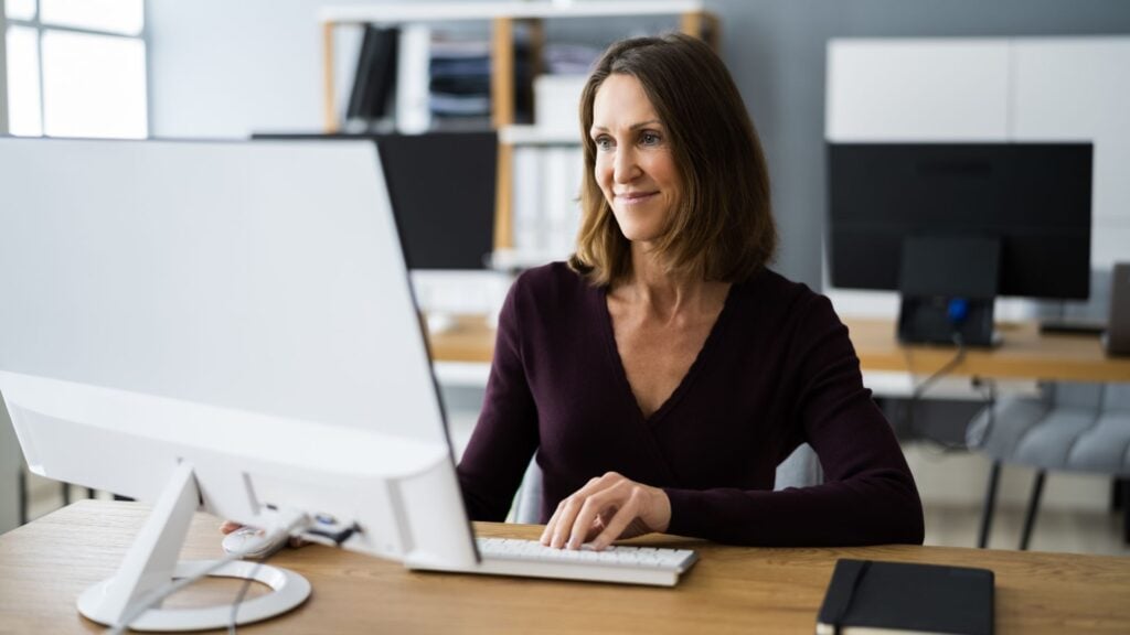 woman on a computer going over staffing agency unemployment claims.