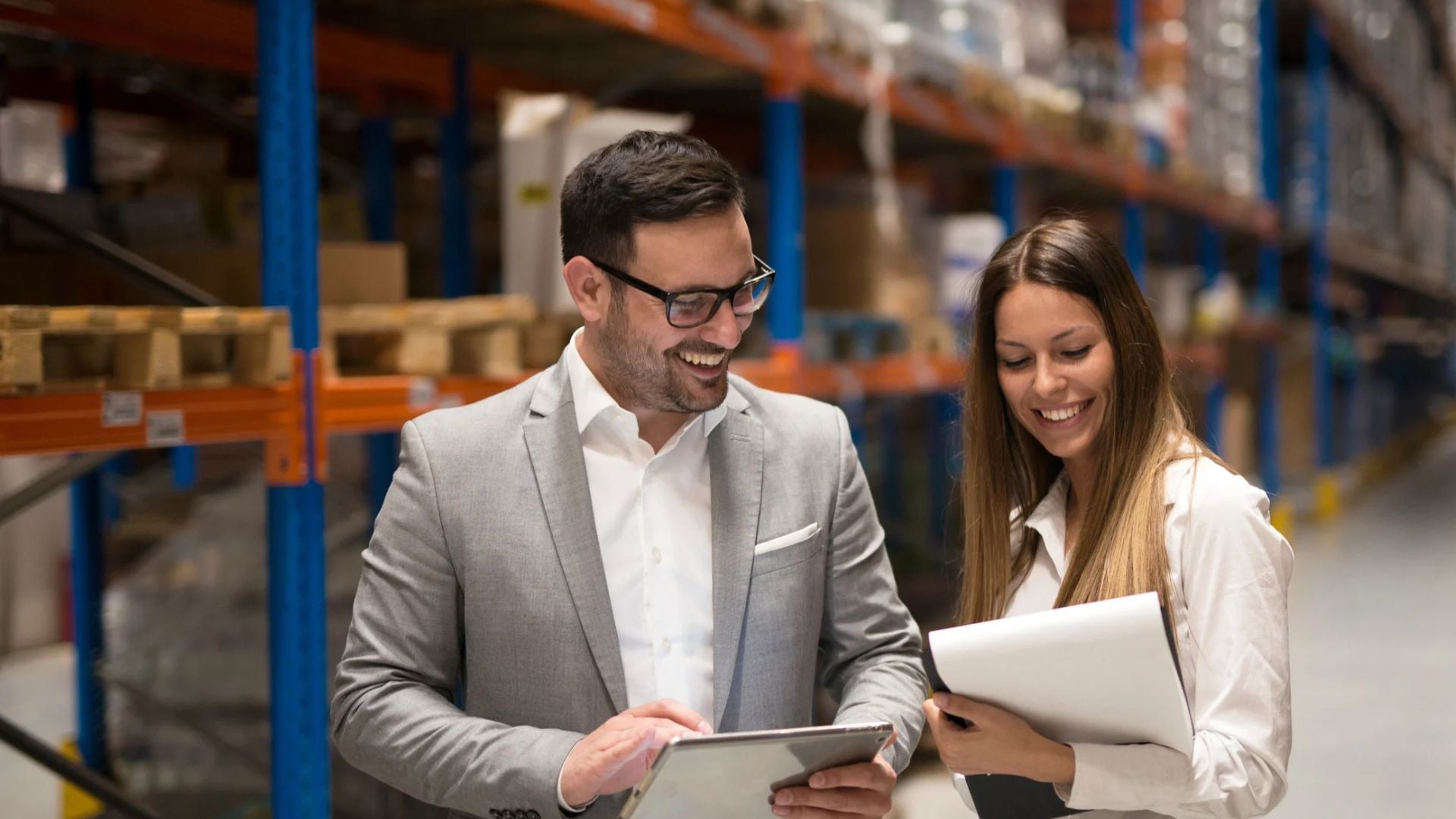 Staffing agency and client representatives reviewing data in a warehouse aisle, representing MSP programs for staffing agencies.
