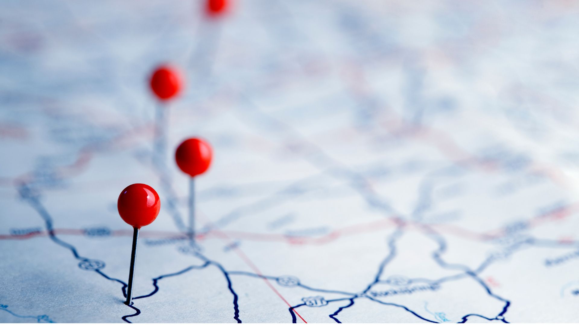 Red pins marking new locations on a road map, representing staffing agency expansion into new markets.